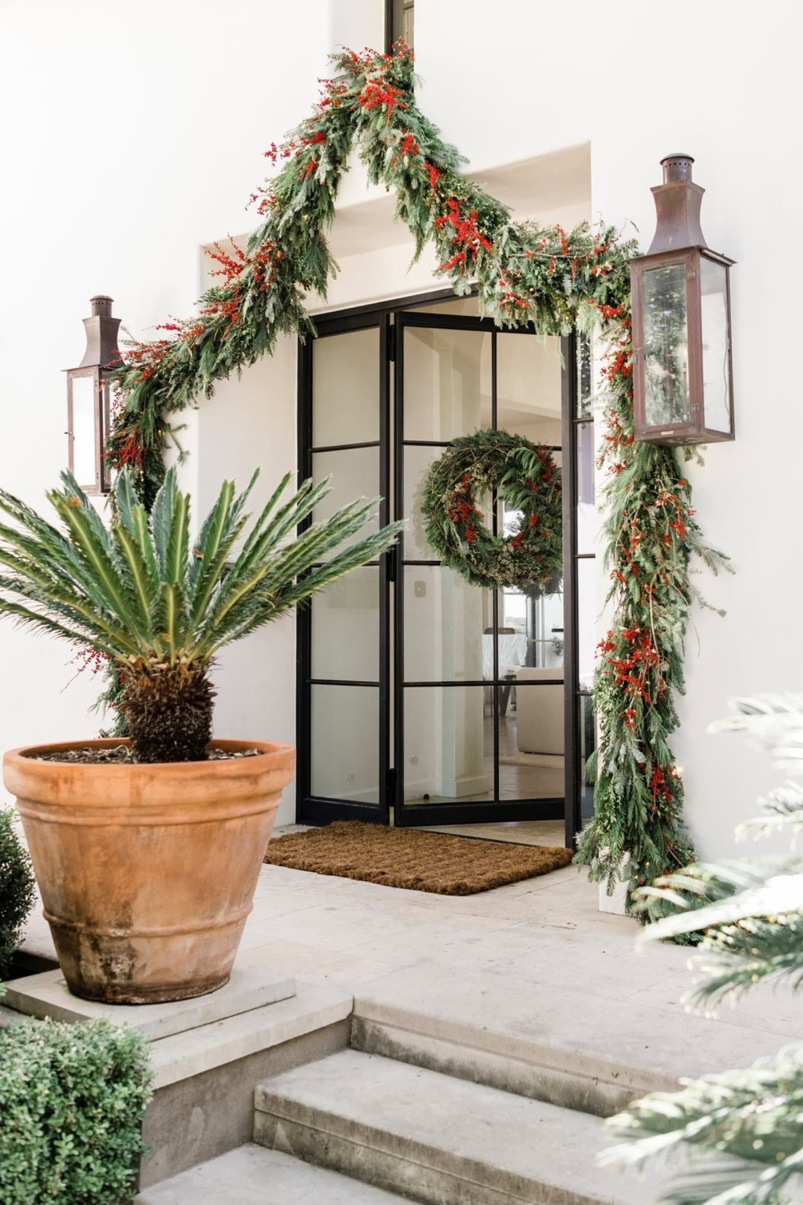 A festive holiday garland and wreath installed at a luxury Austin home's entrance